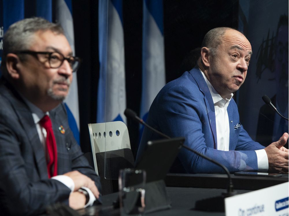 quebec health minister christian dubé, right, and public health director horacio arruda speak during a pandemic news conference in montreal on tuesday, december 28, 2021.