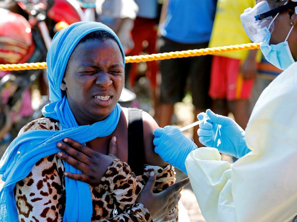 a young woman reacts as a health worker injects her with the ebola vaccine, in goma, democratic republic of congo, in 2019.