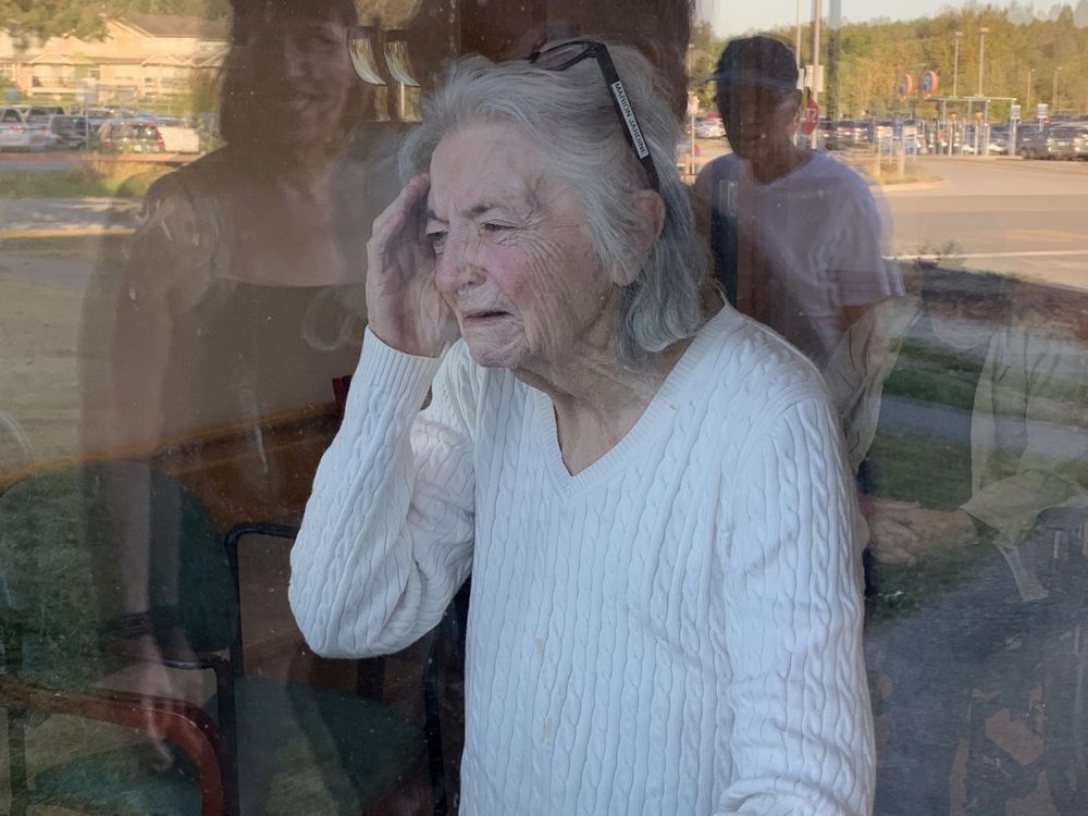 An emotional Marion Jardine looks through the window of her long term care home on her 90th birthday on Sept. 10, 2020. Photo: Cathy Nelson.