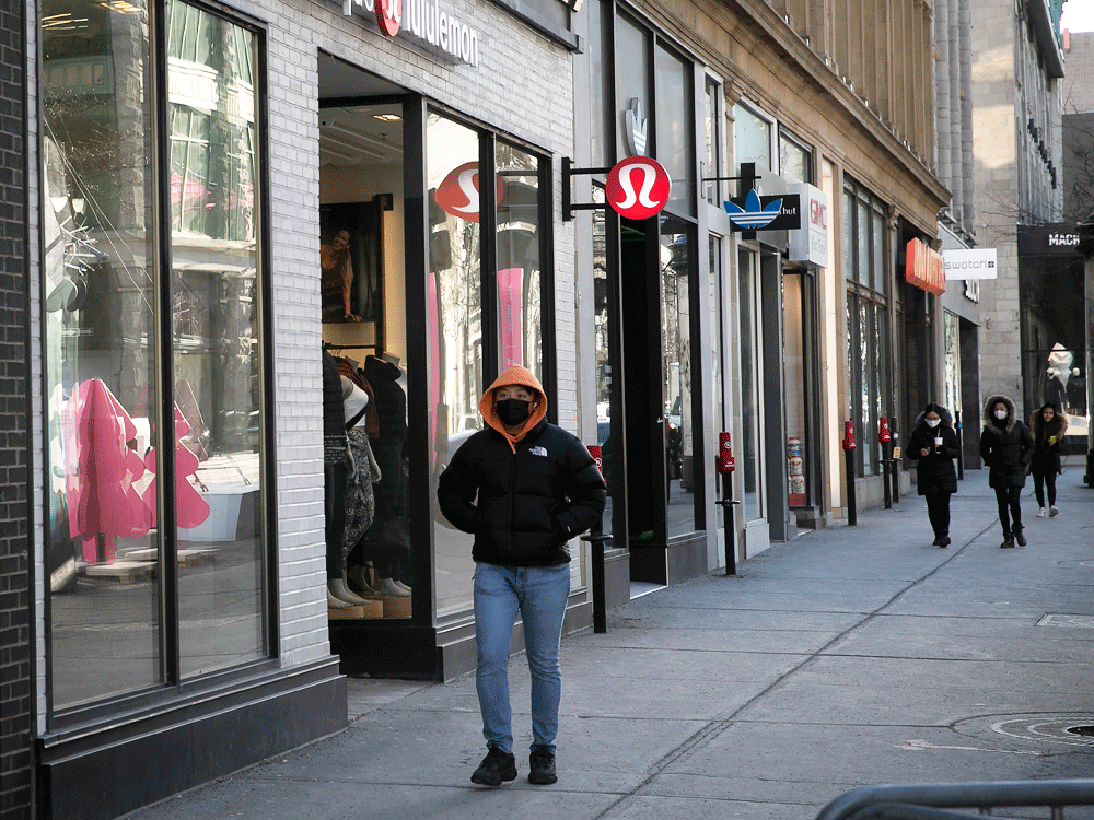 people walk along ste-catherine street in montreal, next to closed stores, during a covid-19 lockdown in quebec, december 29, 2020.