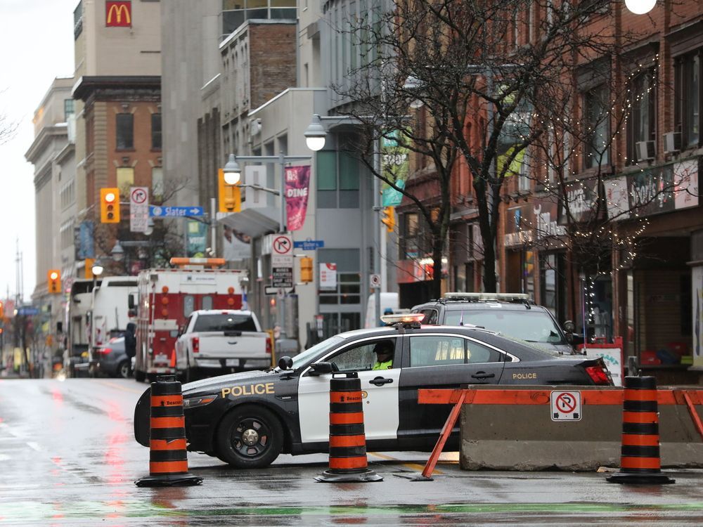 A police vehicle forms part of a blockade at the intersection of Rideau and Bank streets on Thursday.