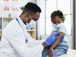 Male physician vaccinating little girl from coronavirus