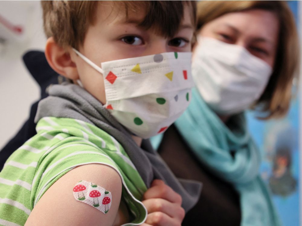 Seven-year-old Justus poses got a bandage after being vaccinated in Germany in December.