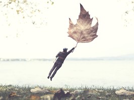 man flying with a big leaf , autumnal surreal concept