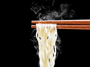 chopsticks holding steaming noodles