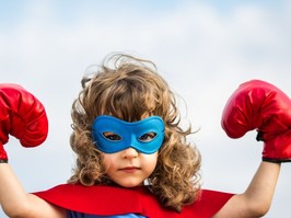 Child dressed up as a superhero with mask and boxing gloves