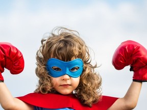 Child dressed up as a superhero with mask and boxing gloves