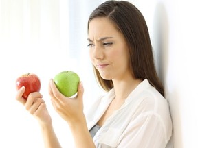 Woman look at a green and red apple