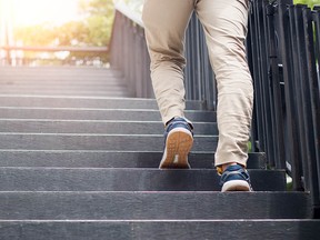 Young man walking up the stairs with sun sport background