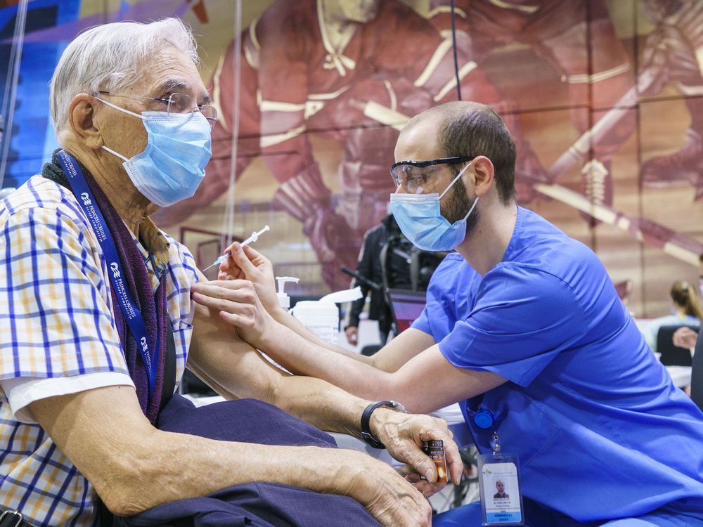 A senior citizen receives a dose of COVID-19 vaccine at a clinic in Montreal, where anyone 60 and over can get a second booster shot.