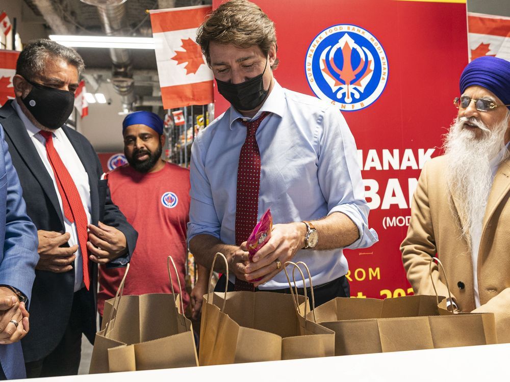 Prime Minister Justin Trudeau helps put together a food hamper during a visit to the Guru Nanak Food Bank in Surrey on Tuesday May 24, 2022.