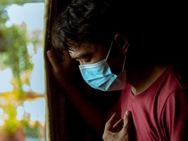 An Asian man wearing a mask has a side effect after suffering from COVID-19.