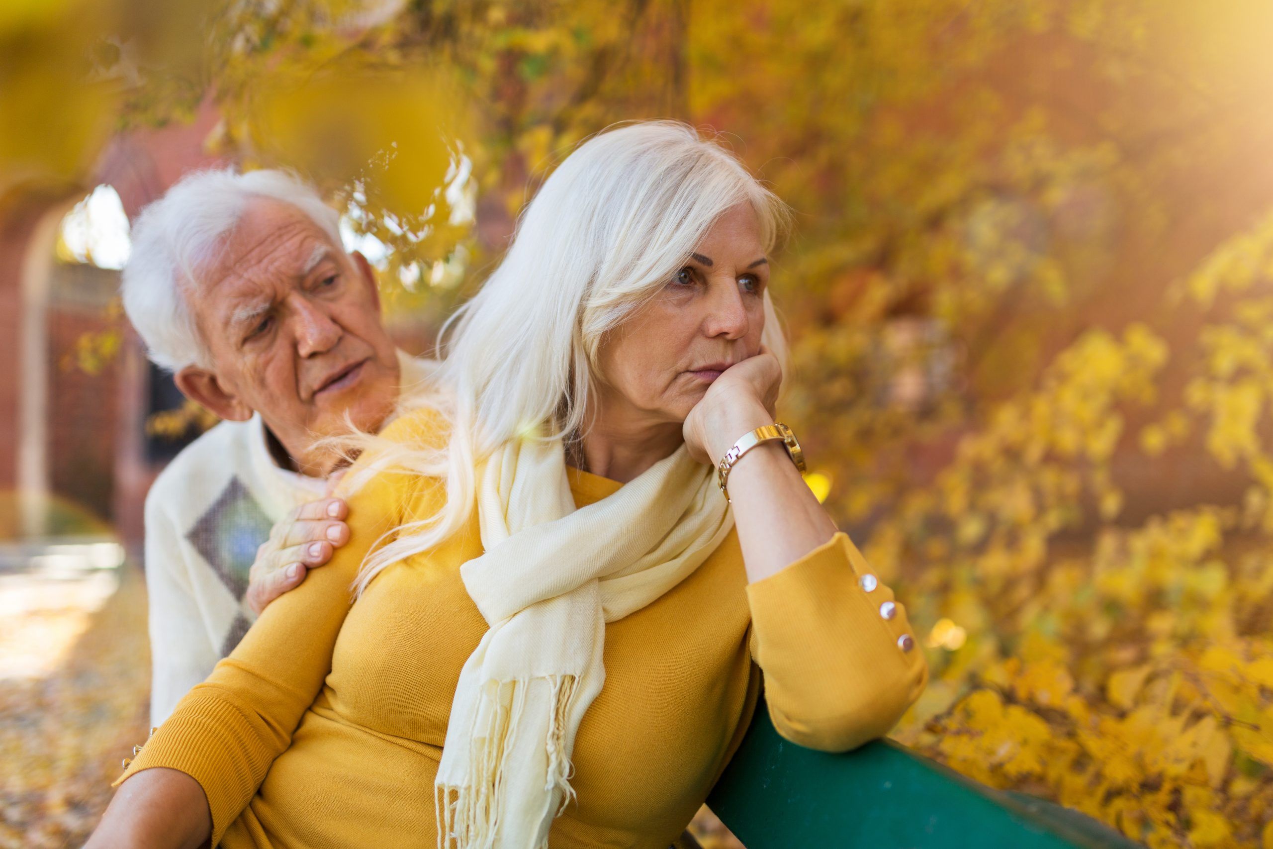 Depressed senior woman consoled by elderly man