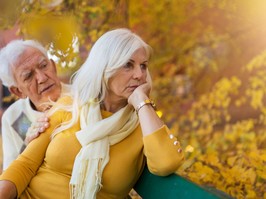 Depressed senior woman consoled by elderly man