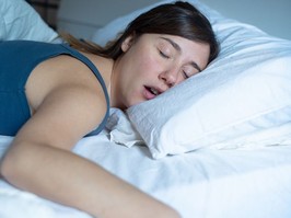 Face close up portrait of woman sleeping in bed and snoring