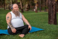 man doing yoga in a park