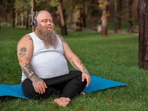 man doing yoga in a park