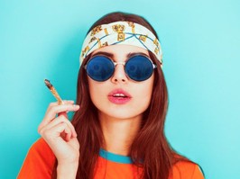 Hippy girl smoking weed and wearing sunglasses
