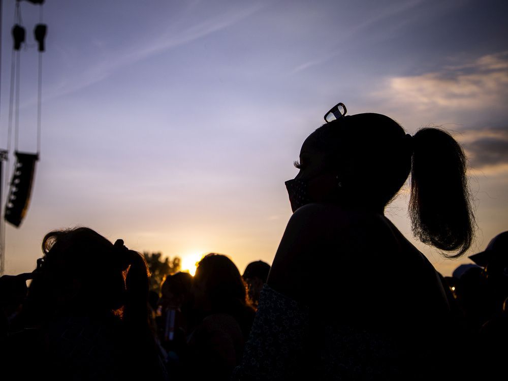 a mask-wearing fan watches tlc as they performed on the rbc stage during bluesfest at lebreton flats on saturday.