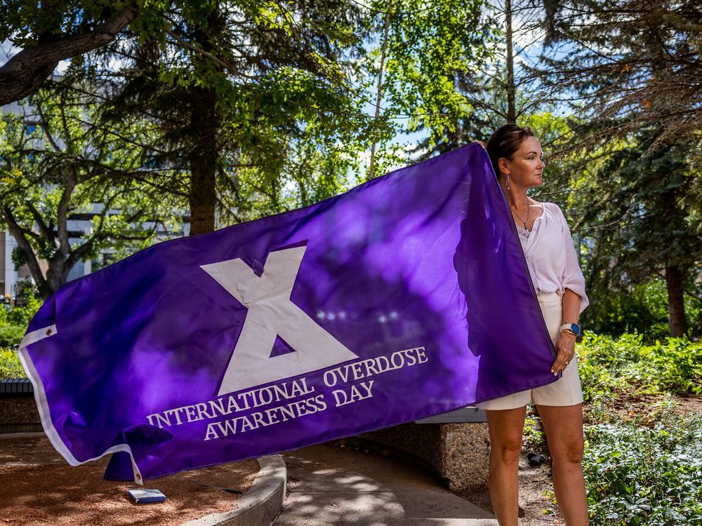 marie agioritis, an advocate with moms stop the harm, holds a flag she has made for the city of saskatoon to fly in recognition of overdose awareness day.