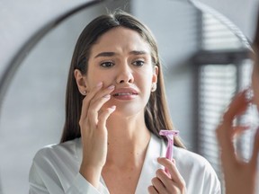 woman looking into mirror distressed