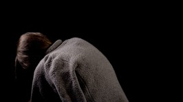 hunchback beggar on black background, spinal diseases in old age, kyphosis