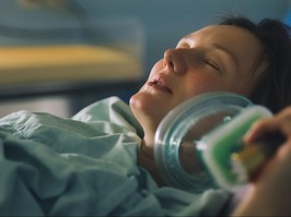 Pregnant woman breathing laughing gas during contractions.