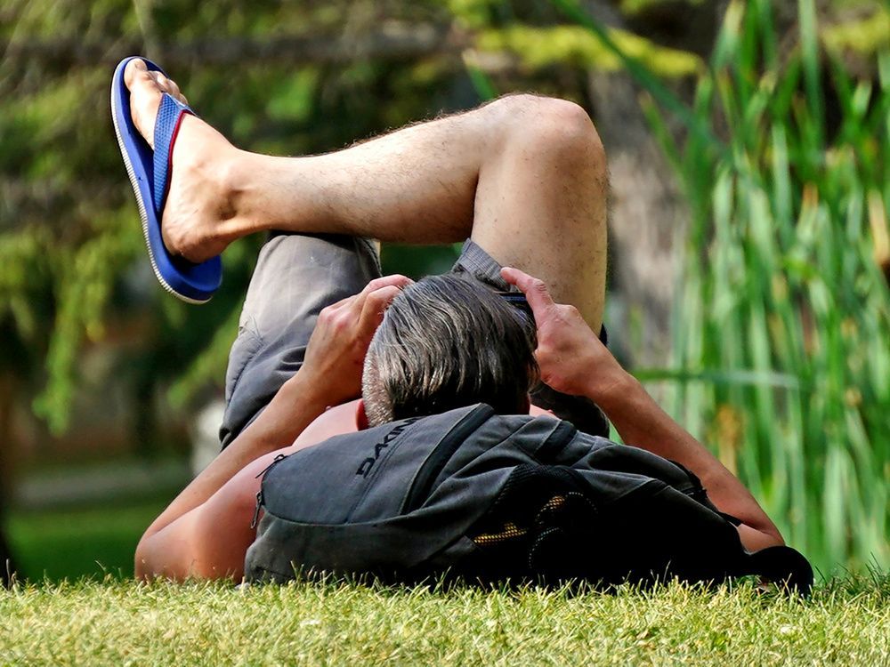 a man relaxes at a park in edmonton as temperatures climbed to 29 c degrees on thursday, aug. 11, 2022.