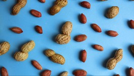 texture of peanuts in shell and without lie on a blue background.