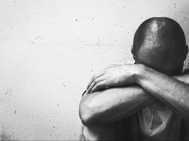 man dealing with addiction. black and white photo. sitting on ground