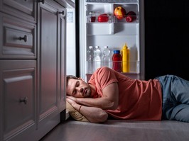 exhausted man sleeping near open refrigerator on kitchen floor