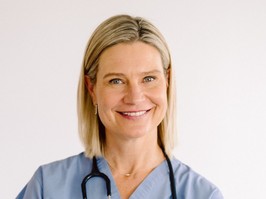 A portrait of dr. Rose Zacharias, wearing. blue pair of scrubs with a stethoscope around her neck. Zacharias speaks to healthing about what parents need to know about COVID when sending their kids back to school.