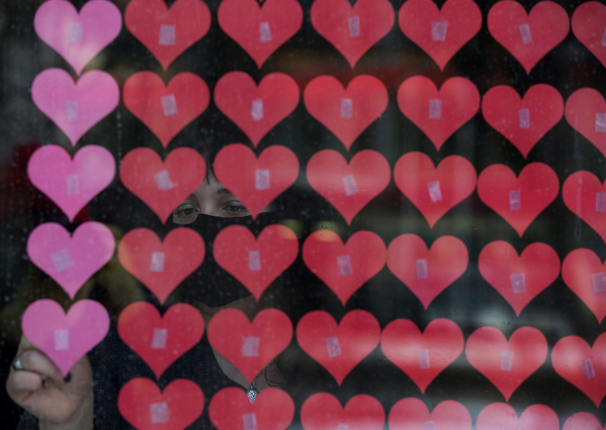 file photo of sara edwards adding more paper hearts, one for every albertan who has died from covid-19, to a memorial at all saints' anglican cathedral in edmonton on jan. 29, 2021. as of oct. 24, 2022, alberta has reported more than 5,000 deaths from the disease in the province.