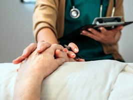 Female doctor comforting older patient