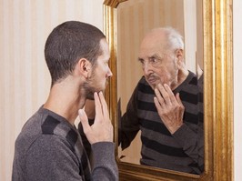 young man looking in mirror seeing older man