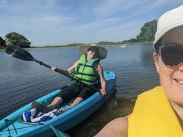 Mother and her daughter kayaking on a body of water.