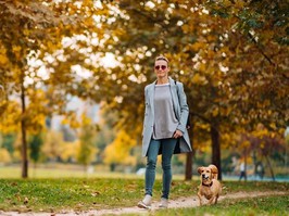 woman walking with dog in park