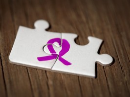 two white puzzle pieces with pink ribbon