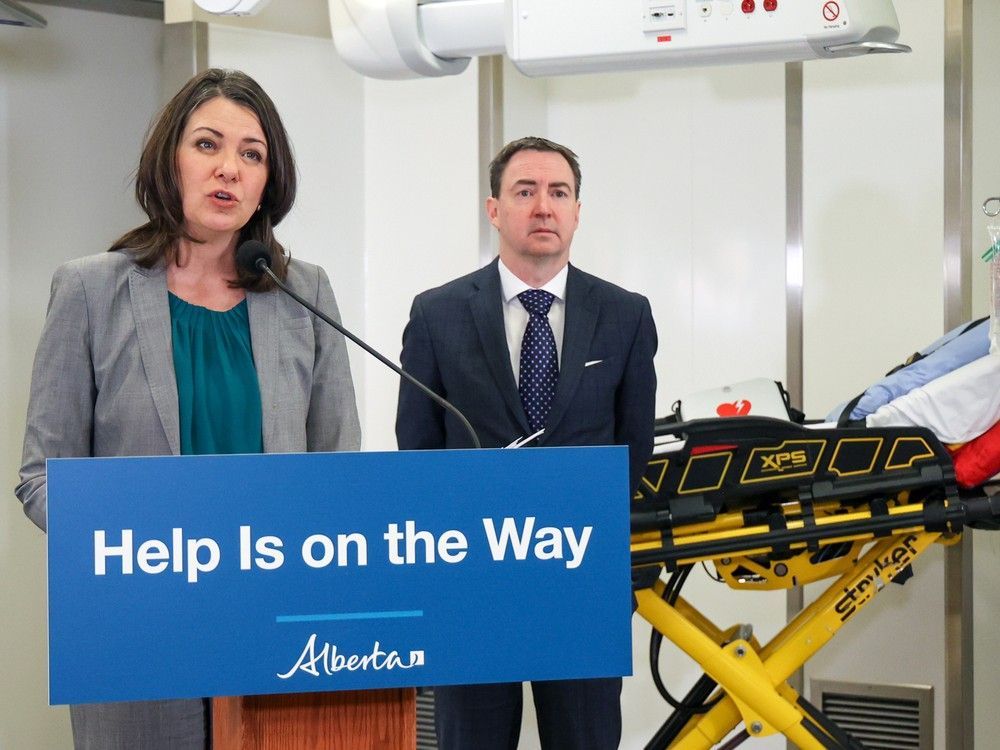 premier danielle smith speaks with health minister jason copping in the background during a press conference on a new initiative to use alternative modes of transportation for non-emergency transfers to hospital. the goal is to help free up paramedics and ambulances for emergency calls. the announcement took place in a training lab at the cal wenzel precision health building next to the foothills hospital on wednesday, december 21, 2022.