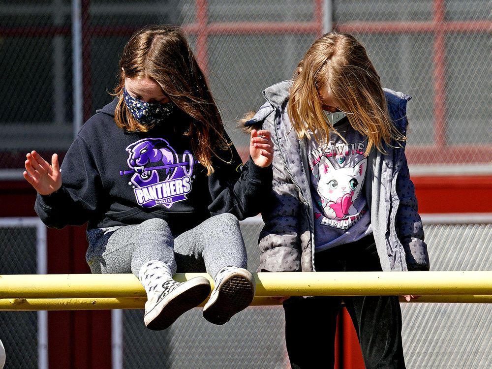 children wear masks while playing during recess in a file photo from 2021.