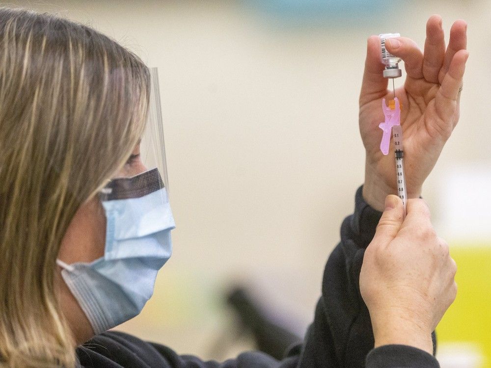 one layer of protection: jill seara, a public health nurse, loads a syringe with the pfizer covid-19 vaccine.