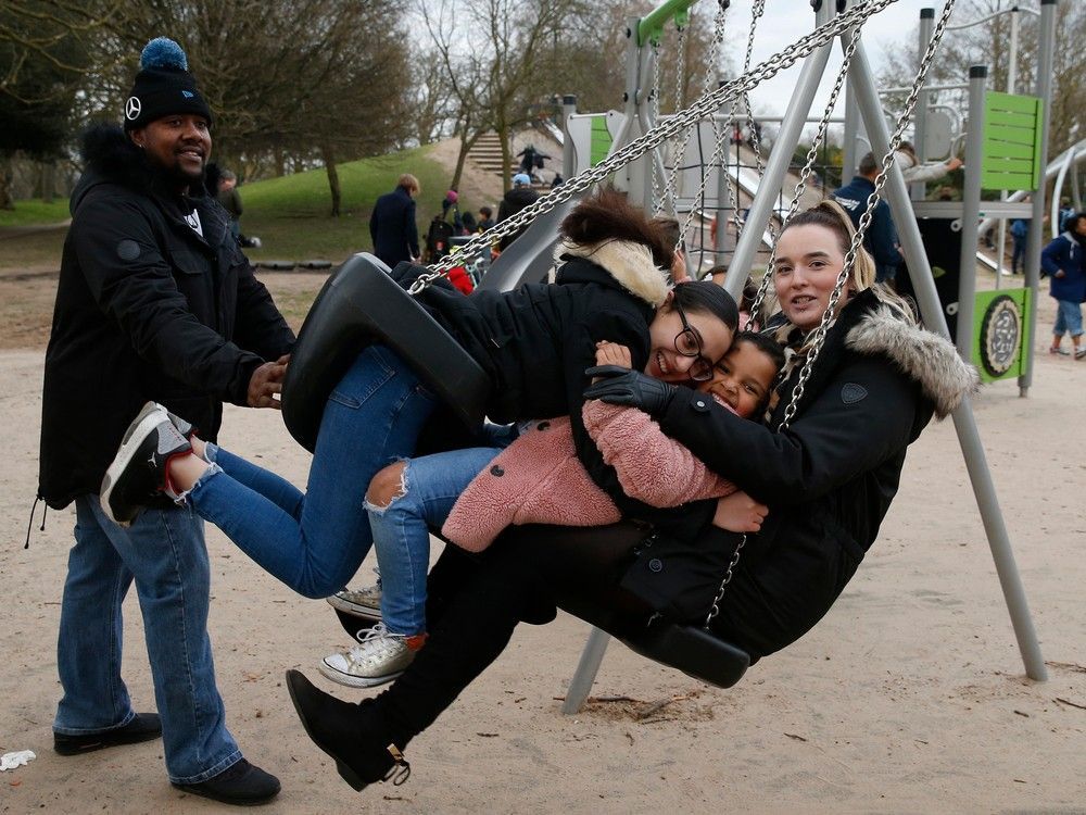 parents trevor daley (l) and rebecca nicholson (r) pose for a photo with their daughter shaniyha daley, 5, (2nd r) and goddaughter trinity, 13, (2nd l) on a swing at a playground in victoria park on march 6, 2021 in london, england. a study compared this and other innovative u.k. parks to smaller ones in the united states and found they promoted much more activity.
