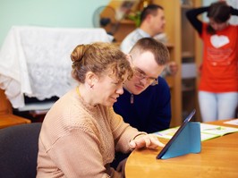 Two friends with disability in rehabilitation centre watching digital tablet