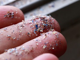 Close up side shot of microplastics lay on people hand.Concept of water pollution and global warming. Climate change idea.