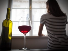 Woman drinking wine alone in the dark room
