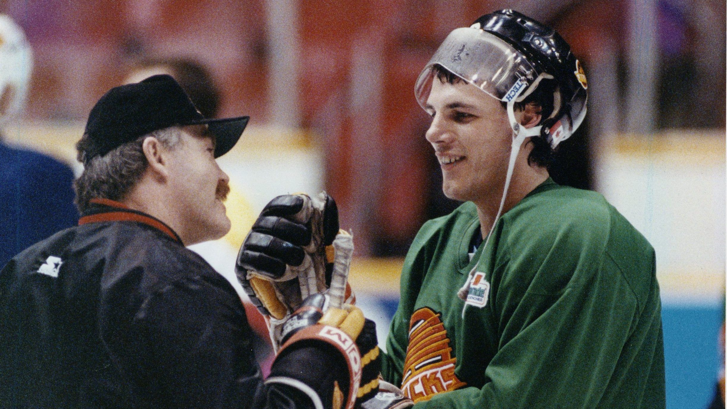 March 31 1991.. Vancouver Canucks assistant coach  Jack McIlhargey (left) shares joke with Gino Odjick. (Mark van Manen / Vancouver Sun)