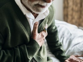 Older man holding chest to signify suffering cardiac arrest
