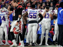 The Buffalo Bills football team gathers as CPR is administered to Damar Hamlin after he collapsed in the first quarter of the NFL Week 17 game.