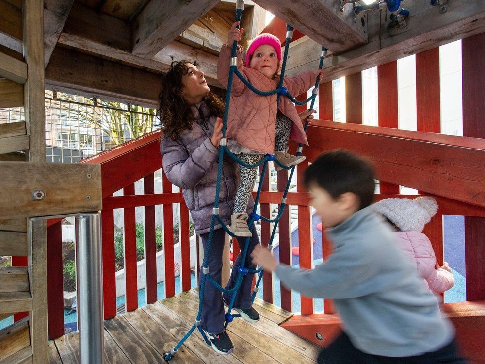 Layla Humayun, 10, left, helps cousin Francesca Fumano, 2, climb a rope ladder while they play at Rainbow Park in Vancouver on Dec. 28.