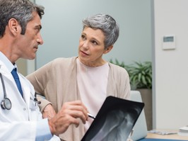 Doctor showing to senior woman x-ray in a medical clinic.